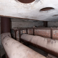 Vrchní část topeniště s potrubím výměníku tepla. Ze stropu vedou komínky o patro výše.